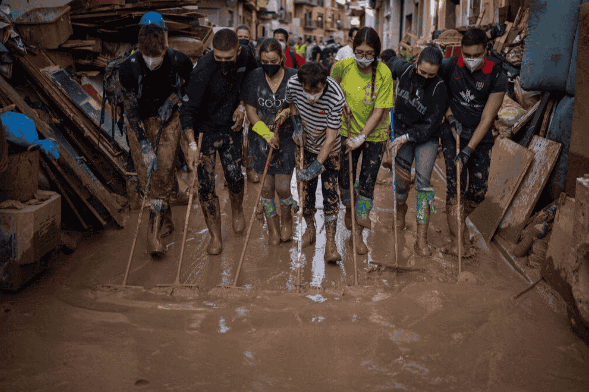 People Sweeping Flooded Street