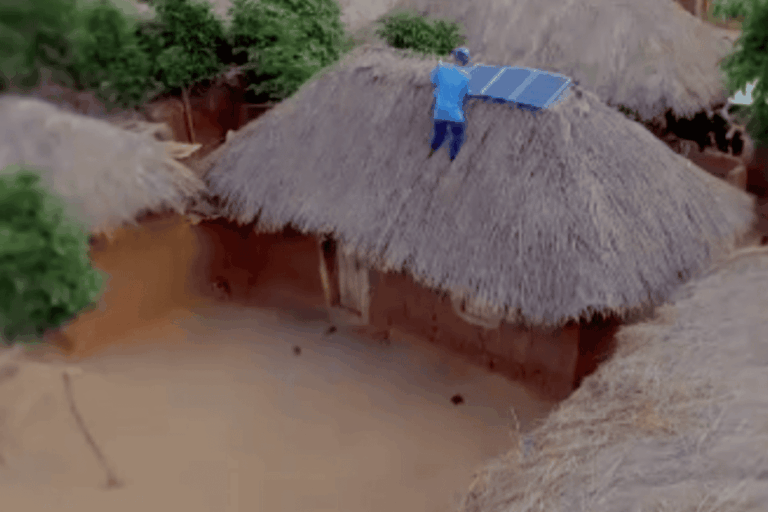 Man Putting Solar Panels On Mud Hut
